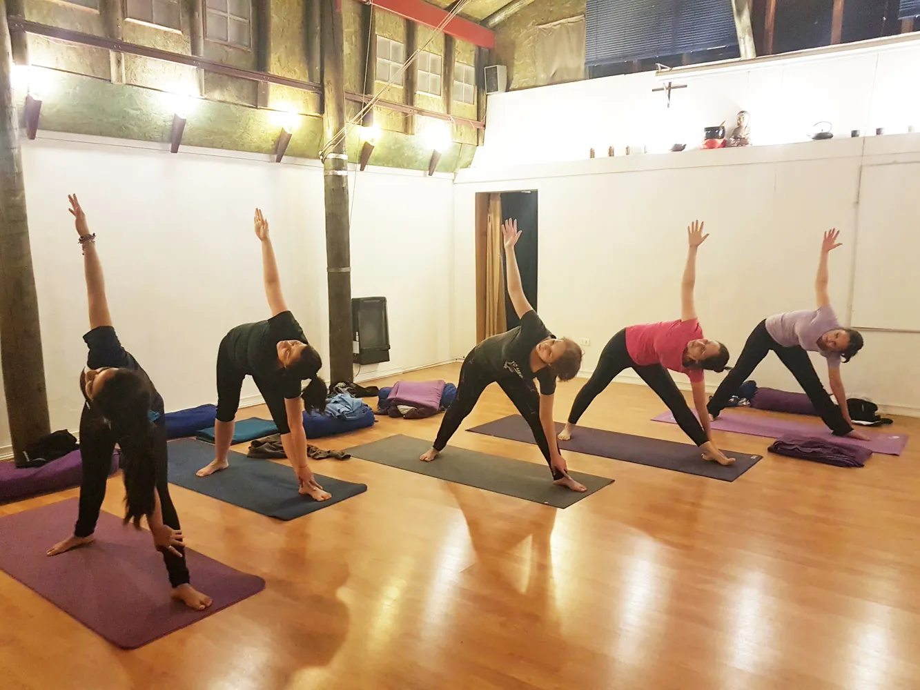 Práctica de Hatha Yoga en grupo en la sala de clases