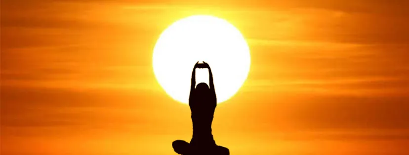 Silueta en meditación frente al sol